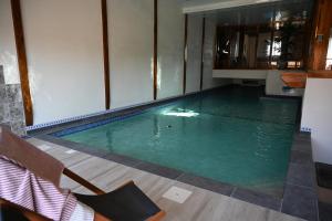 a swimming pool with green water in a room at La grange des Bardins in Blanzaguet-Saint-Cybard-le-Peyrat