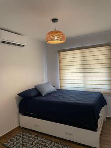 a bedroom with a bed with a blue blanket and a window at Departamento Altata Punta Paraiso in Altata +15 photos