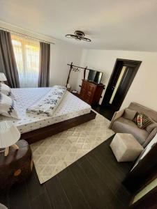 a bedroom with a large bed and a couch at Ograda Bunicilor Gura Humorului in Gura Humorului