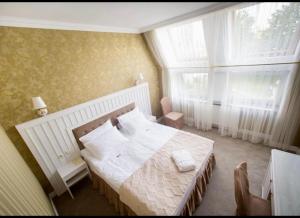 Un dormitorio con una cama grande y una ventana en Boutique Hotel Deluxe, en Kamianets-Podilskyi