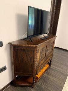 uma televisão em cima de uma cómoda de madeira em Ograda Bunicilor Gura Humorului em Gura Humorului