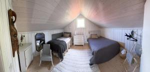 a bedroom with two beds in a small room at Loves Bondgård in Sparreholm