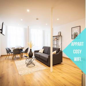 ein Wohnzimmer mit Couch und Tisch in der Unterkunft L'Albatros 011 - Hypercentre * Cosy * Wifi in Saint-Quentin