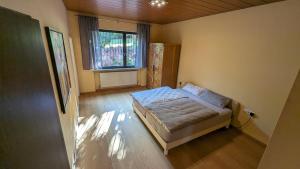 1 dormitorio con 1 cama en una habitación con ventana en FeWo Sonnenschein Bungalow, en Sankt Ingbert