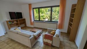 a living room with two couches and a tv at FeWo Sonnenschein Bungalow in Sankt Ingbert