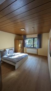 1 dormitorio con 1 cama grande y techo de madera en FeWo Sonnenschein Bungalow, en Sankt Ingbert