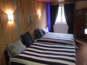 a bedroom with two beds and a window at Le refuge du berger in Choux