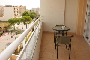 a balcony with a table and chairs in a building at Apartamentos Turísticos Fercomar in Nerja