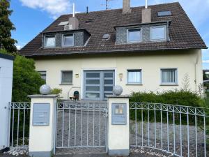 uma casa branca com um portão e uma cerca em Gemütliches Apartment in Köln - SmartTV - Küche em Colônia