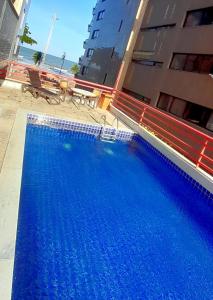 une grande piscine bleue à côté d'un bâtiment dans l'établissement Mercure Recife Navegantes, à Récife