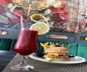 una copa en un vaso junto a una hamburguesa y ensalada en Corniche Casablanca en Casablanca