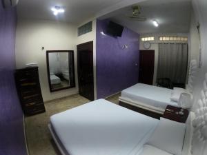 a hotel room with two beds and a mirror at M&F Hotel in Bacalar