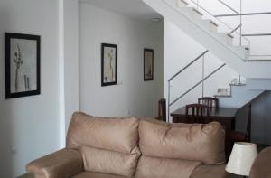 a living room with a couch and a staircase at Apartamentos Turísticos Fercomar in Nerja