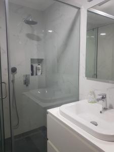 uma casa de banho branca com um lavatório e um chuveiro em Fantastic 2 bedroom Apartment em Tirana