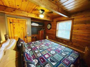 sypialnia z łóżkiem w drewnianym domku w obiekcie The Loft at Bear Mountain log cabins w mieście Eureka Springs