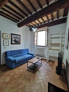 - un salon avec un canapé bleu et une table dans l'établissement Casa Giardino di Piero, à Sansepolcro