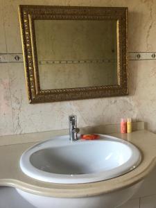 a white sink in a bathroom with a mirror at Camelias in Guimarães