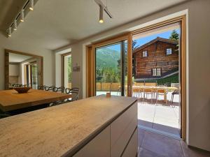 una cocina con mesa y una gran puerta corredera de cristal en Riverside 1st Floor South, en Saas-Fee