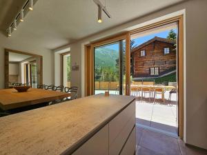 a kitchen with a table and a large sliding glass door at Riverside 1st Floor South in Saas-Fee