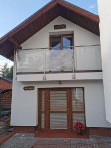 una casa con balcón en la parte superior en Maly domek en Szczecinek