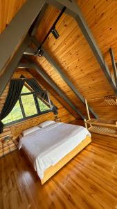 1 dormitorio con 1 cama en un ático de madera en Garvela Bungalow, en Artvin