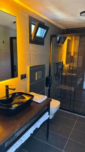 y baño con lavabo negro y ducha. en Garvela Bungalow, en Artvin