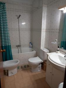 y baño con aseo, bañera y lavamanos. en Duplex apartment with a large sunny terrace 200 m from the sea, en La Mata