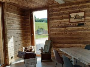 una habitación con una mesa y dos perros mirando por la ventana en Résidence Le Sommet en Les Hôpitaux-Neufs