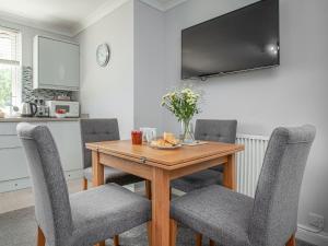 a kitchen with a wooden table with two chairs at First Floor Apartment - Uk44652 in Paignton