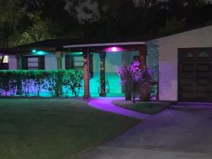ein Haus mit lila und grünen Lichtern in einem Hof in der Unterkunft Sunny days vacation rental LLC in Orlando