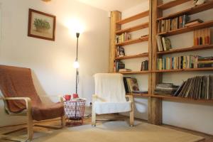ein Wohnzimmer mit 2 Stühlen und einem Bücherregal in der Unterkunft Dřevěnice u Azzyho in Lačnov