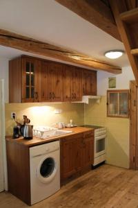 a kitchen with a washing machine and a stove at Dřevěnice u Azzyho in Lačnov