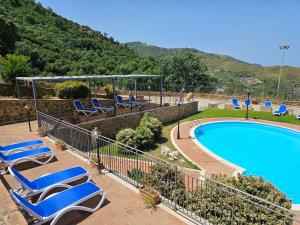 un complexe avec une piscine et des chaises longues dans l'établissement Case Magliolo, à Cefalù