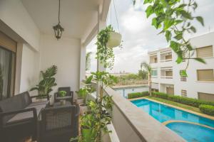 uma varanda com cadeiras e uma piscina em lovely 2 bedroom vacation home with pool/beach em Skhirat