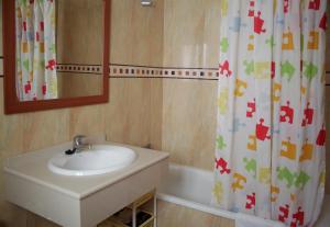 a bathroom with a sink and a shower curtain at Apartamentos Turísticos Fercomar in Nerja