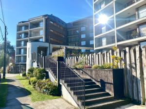 un edificio con scale di fronte a un edificio di Hermoso y moderno departamento a pasos del lago a Puerto Varas