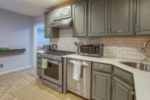 a kitchen with stainless steel appliances and green cabinets at Charming Monroe Township Home - 13 Mi to RU! in East Brunswick