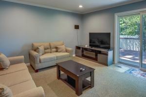 ein Wohnzimmer mit einem Sofa und einem TV in der Unterkunft Charming Monroe Township Home - 13 Mi to RU! in East Brunswick