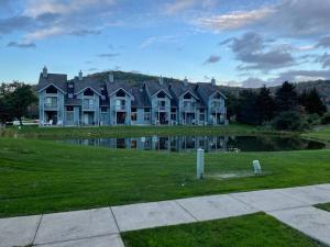 a large house with a pond in front of it at SKIING, HIKING, VILLAGE OF EVILLE MTN ESCAPE in Ellicottville