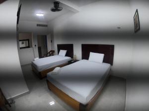 a hotel room with two beds and a mirror at Bacalar in Bacalar