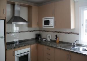 a kitchen with a sink and a microwave at Apartamentos Turísticos Fercomar in Nerja