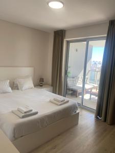 a bedroom with a bed and a sliding glass door at Elite Residense a 150 mts Praia da Rocha in Portimão +122 photos
