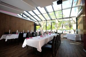 a dining room with tables and chairs and a large window at Hotel zur Heideblüte in Hambühren