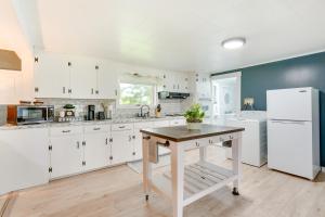 uma cozinha com armários brancos e uma mesa em Outdoorsy Oasis with Screened Porch in Claremont em Claremont