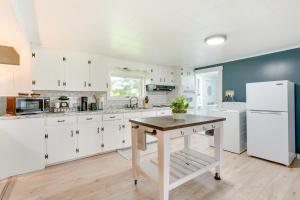 a kitchen with white cabinets and a table in it at Outdoorsy Oasis with Screened Porch in Claremont in Claremont