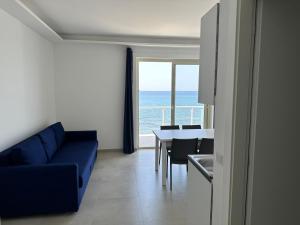 a living room with a blue couch and a table at EmmeBi Appartamenti in Acquedolci