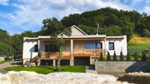 una pequeña casa blanca con un árbol delante en Apartmány pod Janovským vŕškom, 