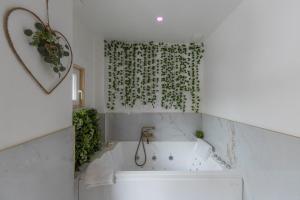 baño con bañera blanca y cortina de ducha verde en La Maginot Room YourHostHelper, en Grenoble