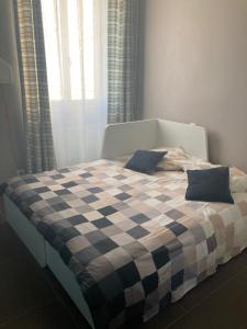 a bed with a black and white checkered blanket at Appartement Le 100m2 in Marseille
