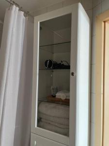 een witte badkamerkast met een spiegel en handdoeken bij Sea view - 2 bedroom - West Pier - Brighton Beach in Brighton & Hove